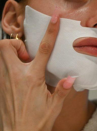 Vrouw krijgt een sheet mask na een gezichtsbehandeling