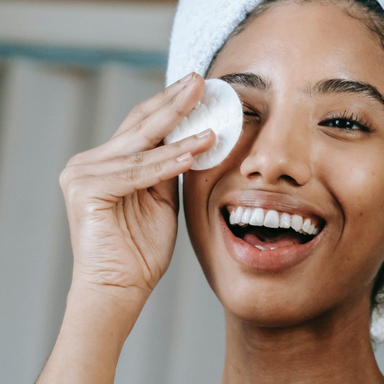 Zorg voor de ogen tijdens huidverzorging Vrouw reinigt voorzichtig haar ogen met een wattenschijfje als onderdeel van haar huidverzorgingsroutine bij Just Your Glow in Maastricht